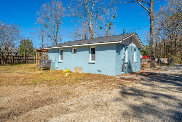 back of house with a shingled roof, a lawn, concrete block siding, crawl space, and fence