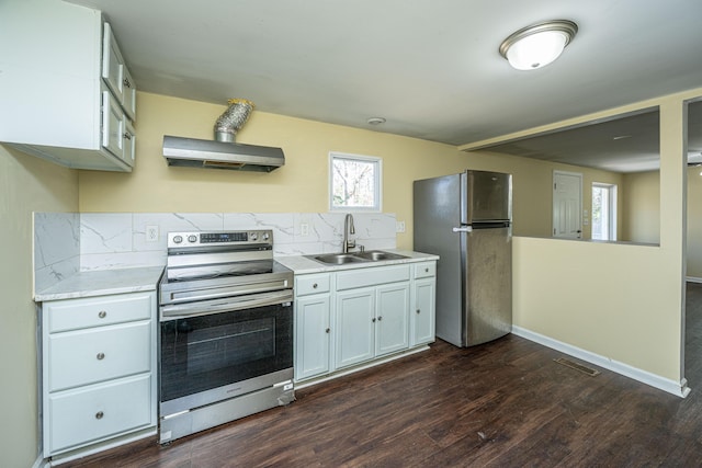 kitchen featuring ventilation hood, appliances with stainless steel finishes, light countertops, and a sink