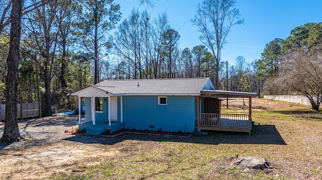 exterior space featuring a yard, roof with shingles, and fence