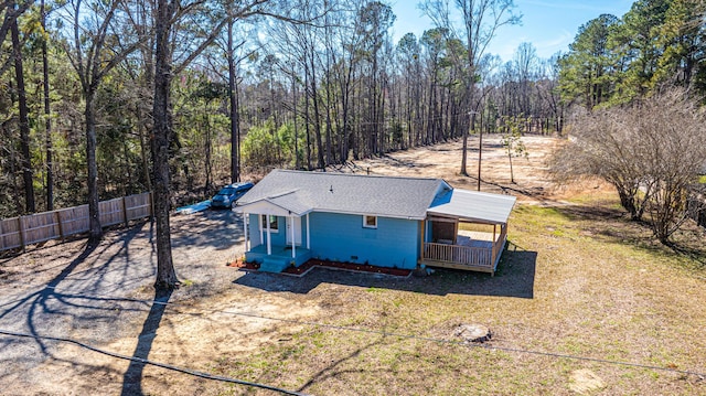 exterior space with driveway, a shingled roof, and fence