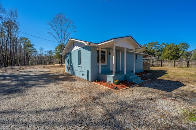 view of side of property featuring concrete block siding and fence