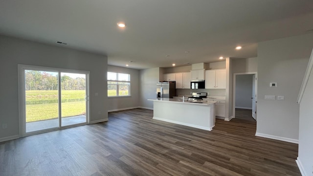 kitchen featuring white cabinetry, appliances with stainless steel finishes, dark hardwood / wood-style floors, and a center island with sink