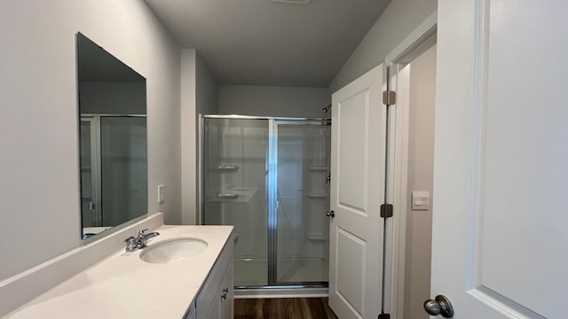 bathroom with vanity, a shower with shower door, and wood-type flooring