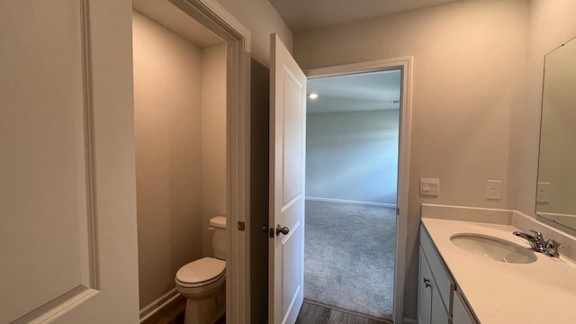 bathroom with vanity, toilet, and hardwood / wood-style floors