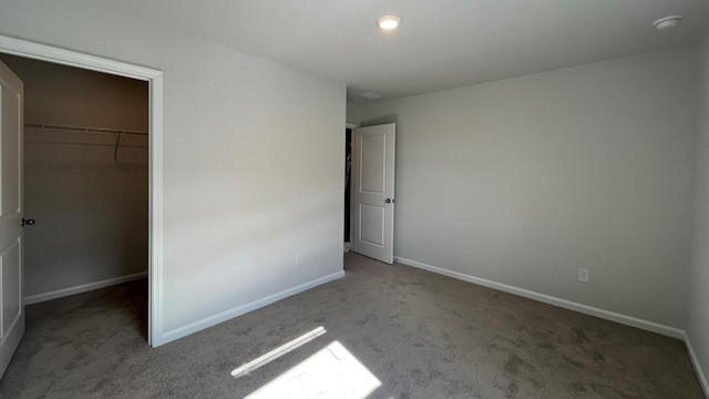 unfurnished bedroom with carpet floors, a spacious closet, and a closet