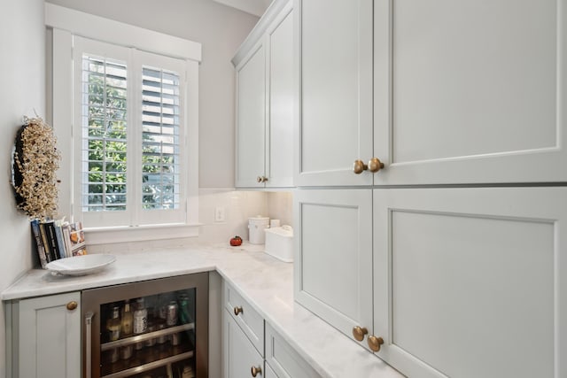 bar featuring beverage cooler and decorative backsplash