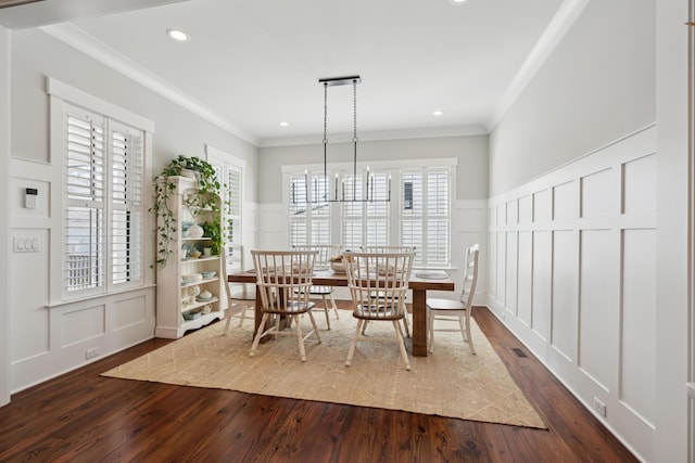 dining area featuring crown molding, dark wood finished floors, recessed lighting, a decorative wall, and an inviting chandelier