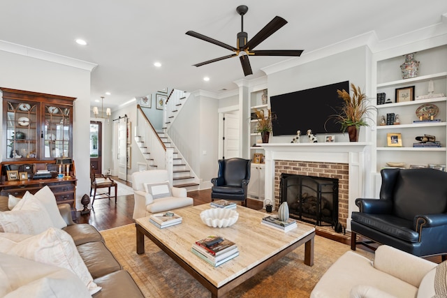 living room featuring built in features, a fireplace, stairway, and wood finished floors