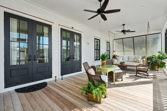 wooden terrace with french doors, outdoor lounge area, and a ceiling fan