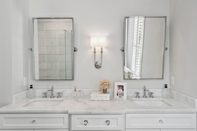 full bathroom featuring a stall shower, a sink, and double vanity