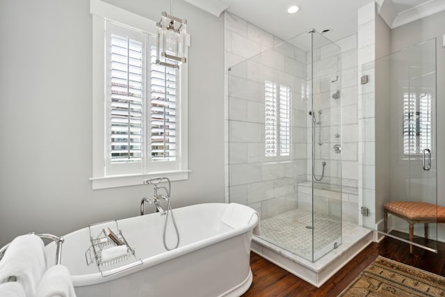 full bathroom featuring a stall shower, a freestanding bath, recessed lighting, and wood finished floors