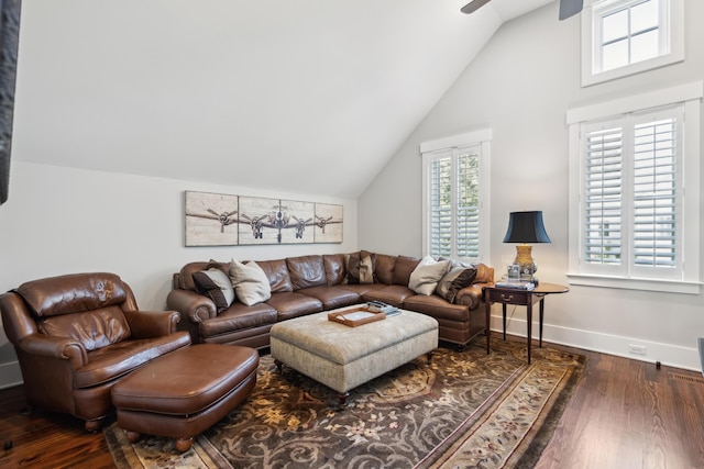 living room featuring lofted ceiling, dark wood-style flooring, ceiling fan, and baseboards