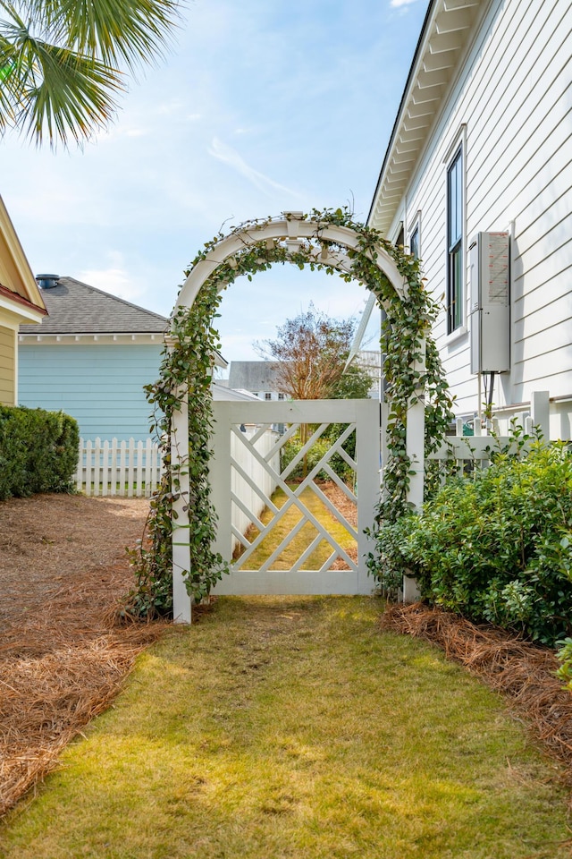 view of gate featuring fence and a lawn