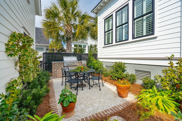 view of patio featuring outdoor dining space, a grill, area for grilling, and fence