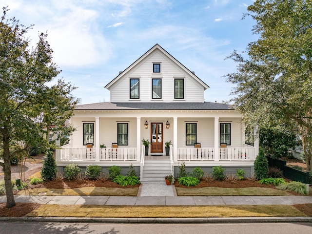 view of front facade featuring covered porch and roof with shingles