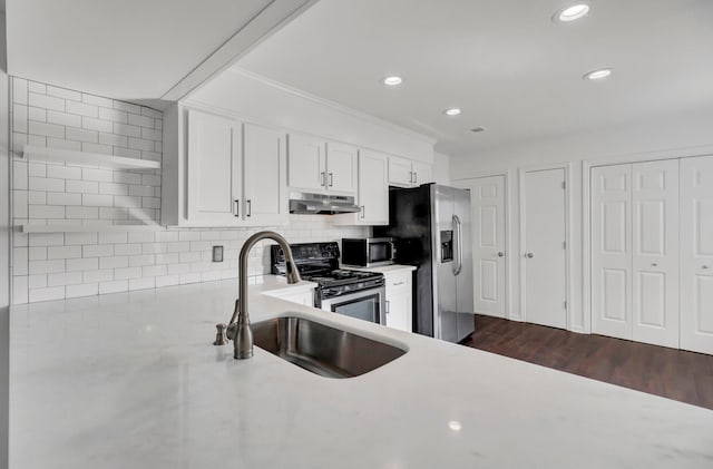 kitchen featuring sink, stainless steel appliances, white cabinets, dark hardwood / wood-style flooring, and decorative backsplash