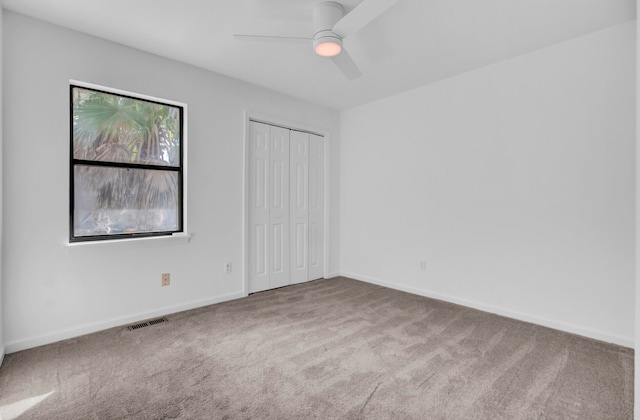 empty room featuring ceiling fan and carpet