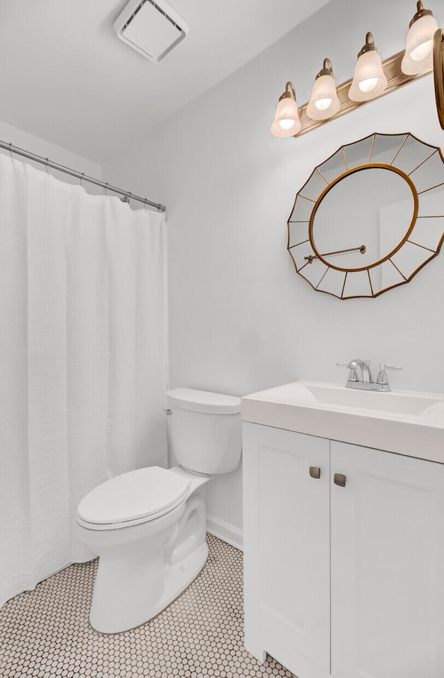 bathroom featuring vanity, tile patterned floors, and toilet