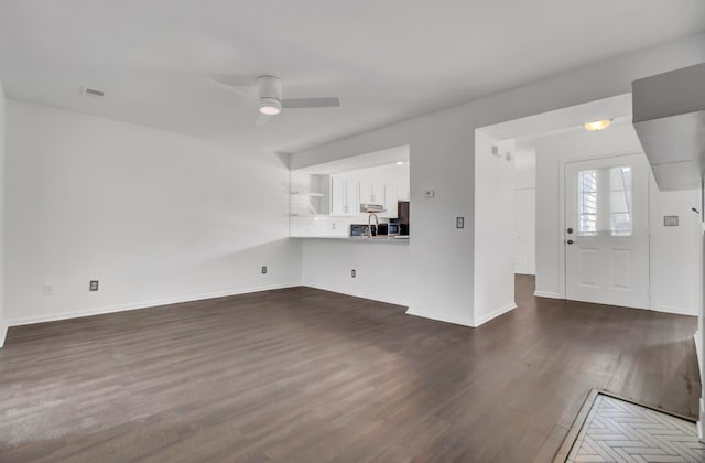 unfurnished living room with dark hardwood / wood-style floors and ceiling fan