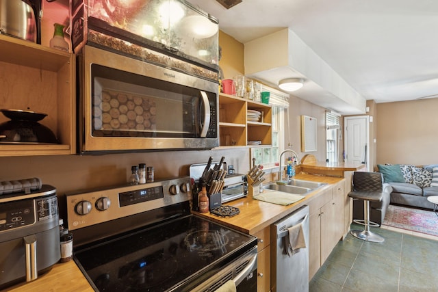 87 America St Unit A, B, C, Charleston, SC 29403 - kitchen with appliances with stainless steel finishes, a sink, open shelves, tile patterned flooring, and wood counters