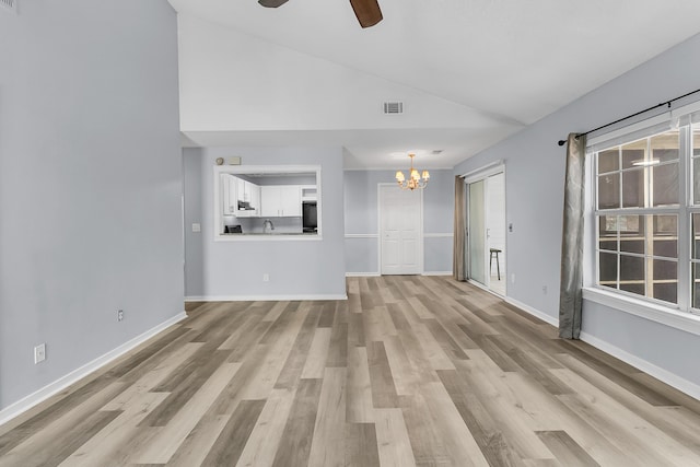 unfurnished living room with ceiling fan with notable chandelier, light hardwood / wood-style floors, high vaulted ceiling, and sink