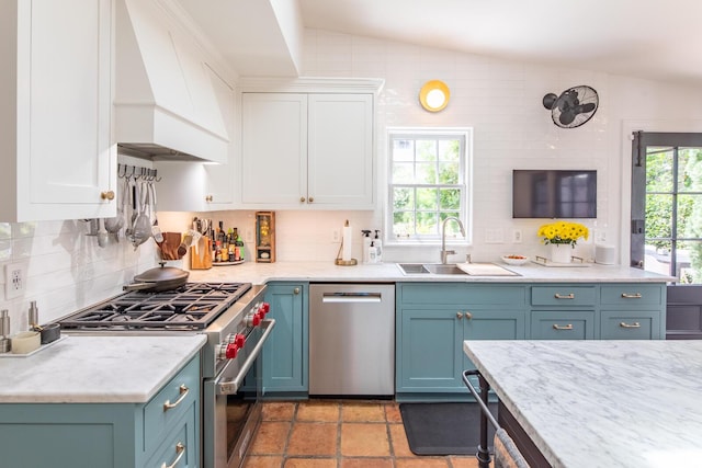 kitchen with stainless steel appliances, custom exhaust hood, a sink, and decorative backsplash