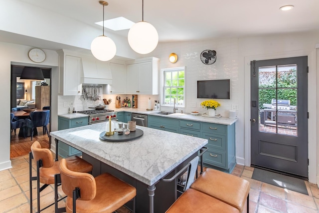 kitchen with a sink, stainless steel dishwasher, white cabinetry, backsplash, and custom exhaust hood