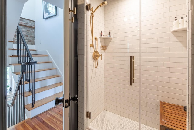 bathroom featuring a shower stall and wood finished floors