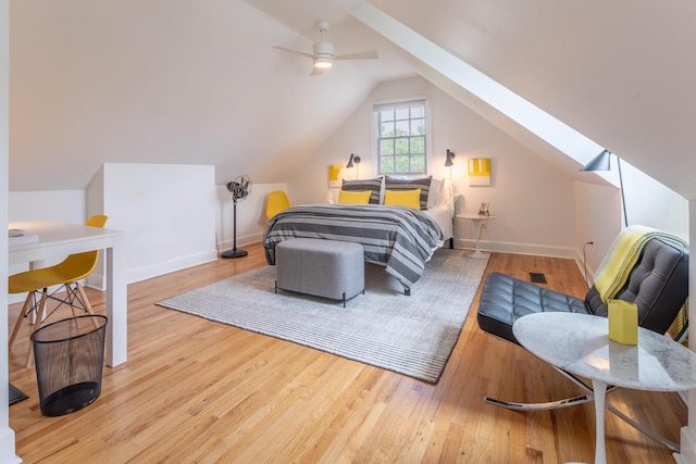 bedroom with a skylight, wood finished floors, vaulted ceiling, and baseboards