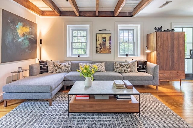 living area with beam ceiling, wood finished floors, and wood ceiling