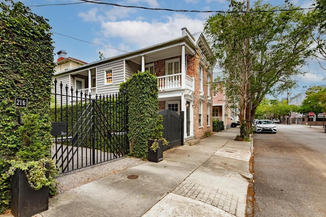 view of front facade with brick siding and a gate