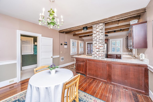 kitchen with decorative light fixtures, sink, dark hardwood / wood-style flooring, a notable chandelier, and beam ceiling