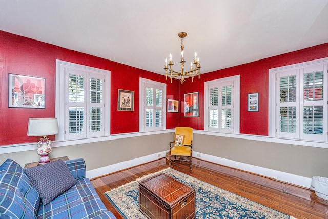 sitting room with wood-type flooring, plenty of natural light, and an inviting chandelier