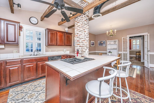 kitchen featuring sink, beam ceiling, stainless steel appliances, tile countertops, and light wood-type flooring