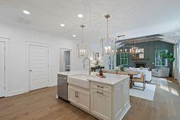 kitchen featuring a fireplace, dark wood finished floors, light countertops, and decorative light fixtures