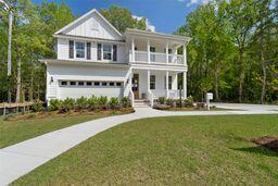 traditional-style house featuring covered porch, concrete driveway, a front yard, and a balcony