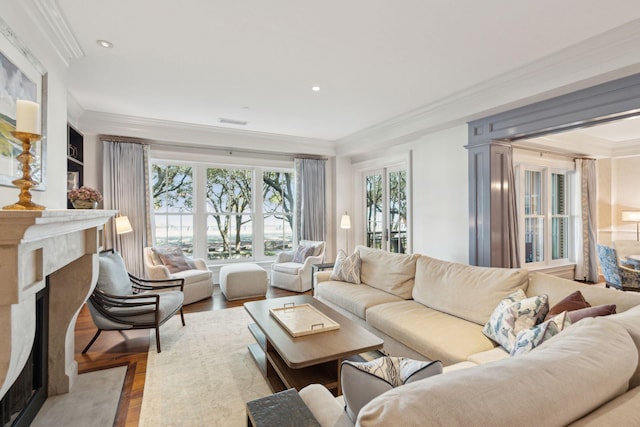 living room featuring crown molding, a high end fireplace, and light wood-type flooring