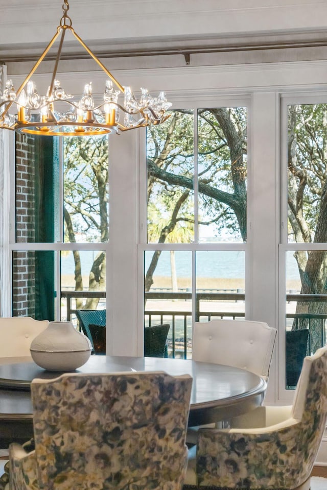 dining room with a notable chandelier and a water view