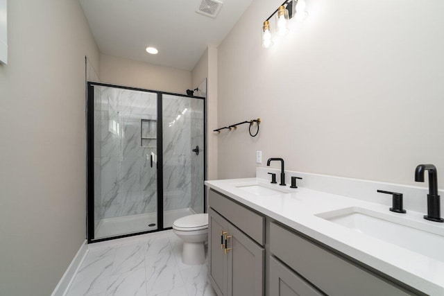 bathroom featuring vanity, a shower with door, and toilet