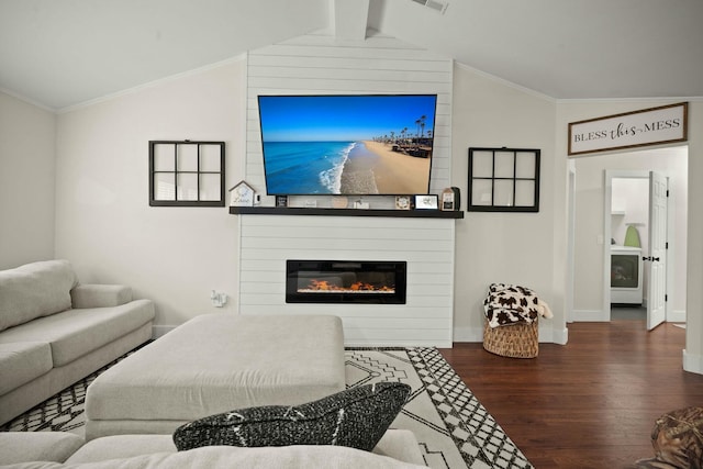 living room with crown molding, a fireplace, dark hardwood / wood-style flooring, washer / clothes dryer, and vaulted ceiling