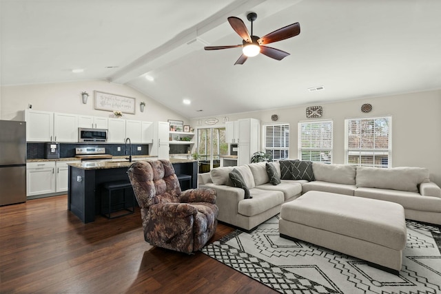 living room with ceiling fan, dark hardwood / wood-style flooring, sink, and vaulted ceiling with beams