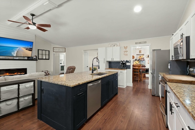 kitchen with sink, dark wood-type flooring, white cabinetry, stainless steel appliances, and an island with sink