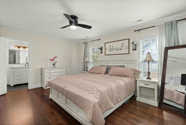 bedroom with ceiling fan, connected bathroom, dark hardwood / wood-style flooring, and ornamental molding