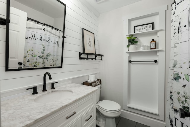 bathroom featuring vanity, toilet, and walk in shower