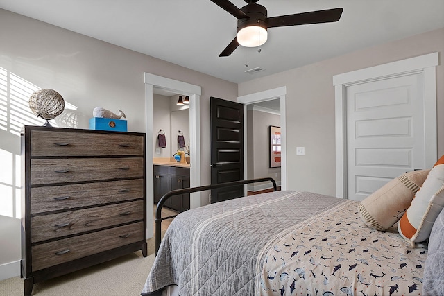 bedroom with light carpet, ensuite bath, visible vents, and a ceiling fan