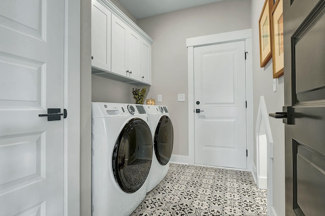 laundry area featuring separate washer and dryer, light tile patterned flooring, cabinet space, and baseboards