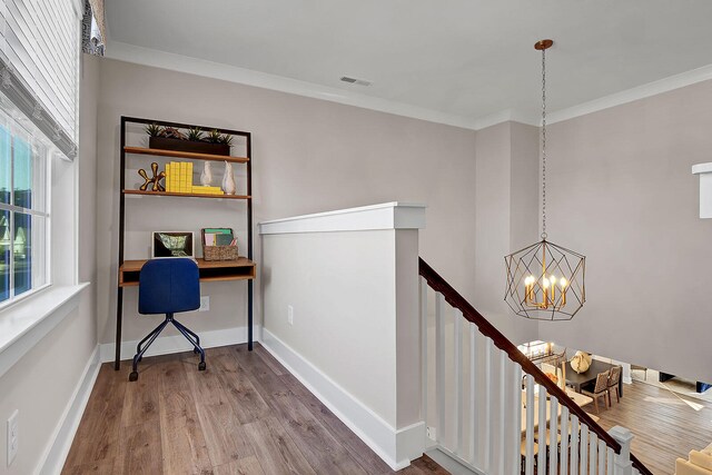 interior space featuring crown molding, baseboards, wood finished floors, and a notable chandelier