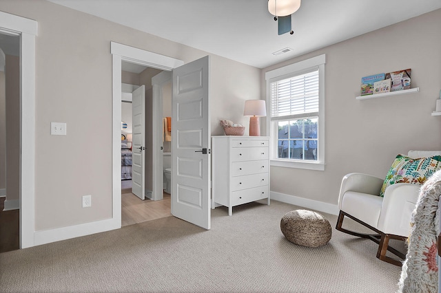 sitting room with baseboards, visible vents, and carpet flooring