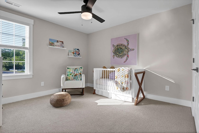 bedroom with baseboards, visible vents, a ceiling fan, carpet flooring, and a nursery area