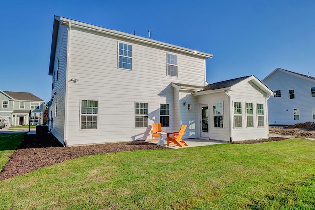 back of property with a yard and a patio